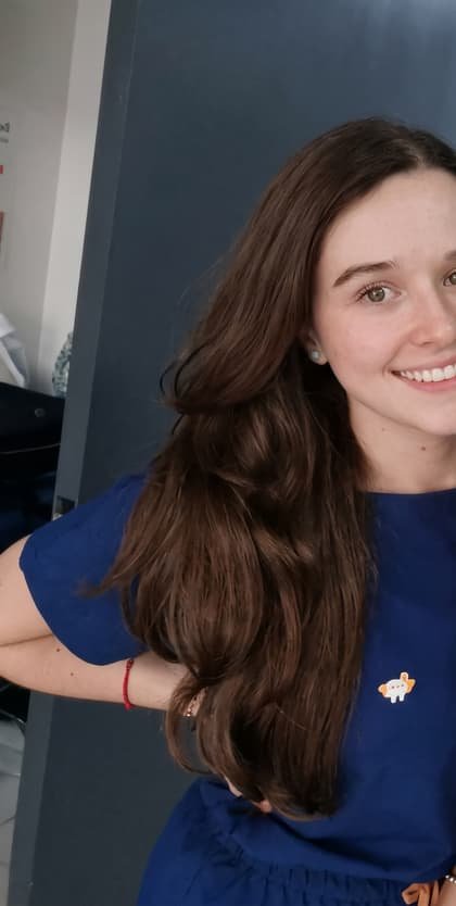 La doctora Katherynne Suárez sonriendo, con blusa azul, junto a una compañera