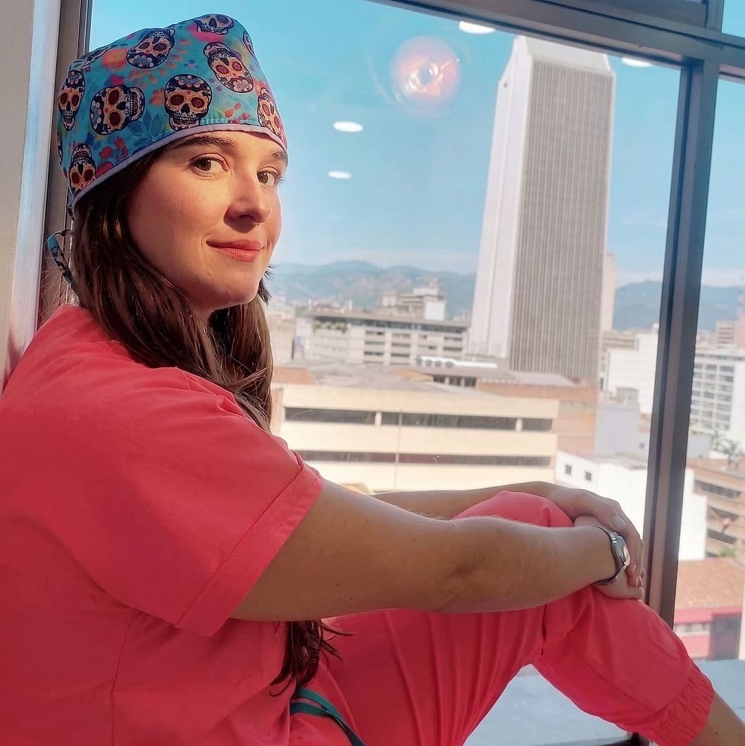 La doctora Katherynne Suárez junto a la ventana de su consultorio, con el centro de Medellín al fondo