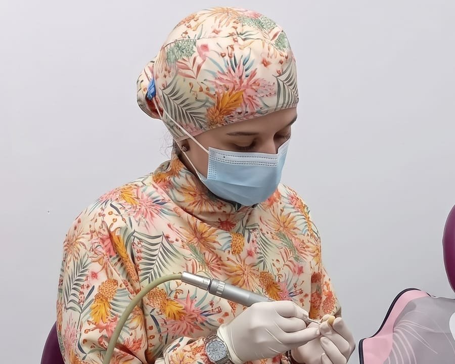 La doctora Katherynne Suárez trabajando con gorro y tapabocas en su consultorio